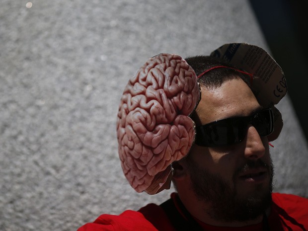 Pesquisador exibe chapéu de cérebro durante um protesto na Espanha (Foto: Susana Vera/Reuters)