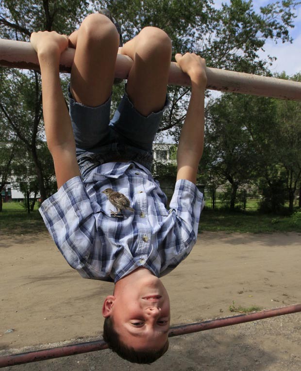 Pássaro não desgruda de Vadim Veligurov; (Foto: Ilya Naymushin/Reuters)