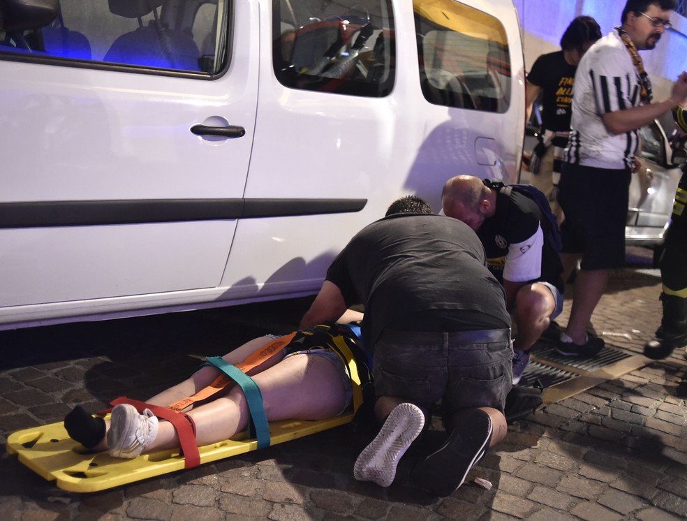 Médicos socorrem mulher ferida durante a confusão (Foto: Reuters)