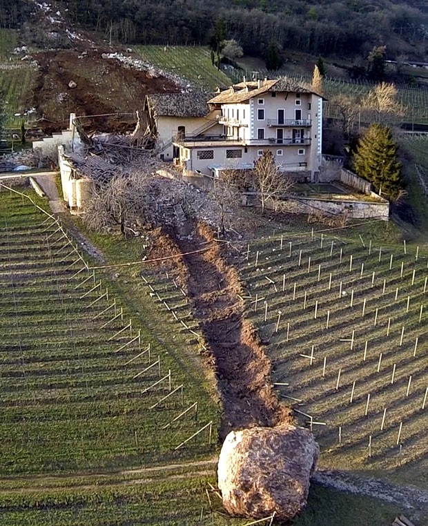 Casa escapou por pouco de ser destruída por duas pedras enormes que deslizaram de uma montanha em Ronchi di Termen (Foto: Markus Hell/Tareom.com/AP)