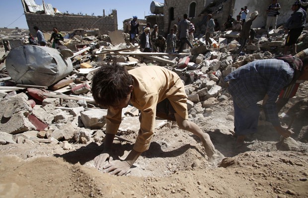 Crianças brincam em entulho após ataques sauditas em Sanaa, capital do Iêmen, nesta sexta (1º) (Foto: Hani Mohammed/AP)