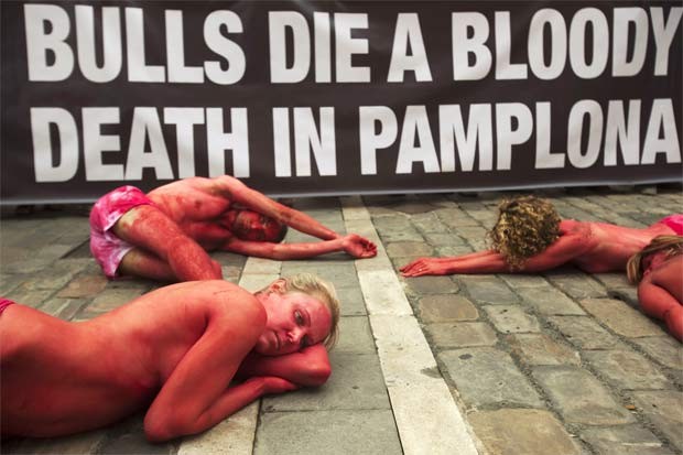 Grupo faz protesto contra a tourada nesta quinta (5) na Espanha. Os manifestantes se pintaram de vermelho e preto e formaram a frase ‘parem com a tourada’. No dia 6, o festival de tourada San Fermin começa em Pamplona, durando uma semana (Foto: Reuters)