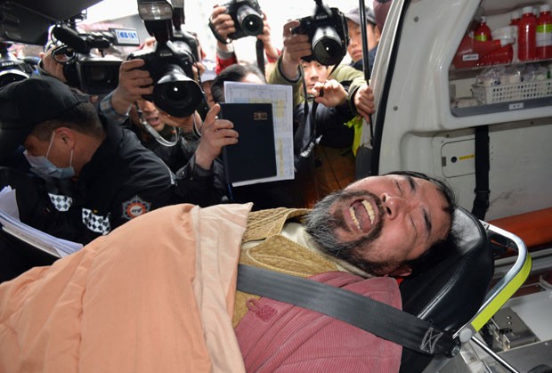 Kim Ki-jong, autor de ataque contra o embaixador dos EUA na Coreia do Sul, Ã© carregado ao chegar a hospital em Seul nesta quinta-feira (5) (Foto: Han Jong-chan/Yonhap/Reuters)
