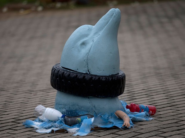 Escultura retrata golfinho com pneu preso ao pescoço  (Foto: AP Photo / Silvia Izquierdo)