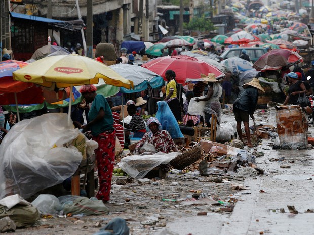 Vendedores de rua trabalham enquanto o furacão Matthew se aproxima de Porto Príncipe, no Haiti (Foto: Carlos Garcia Rawlins/Reuters)