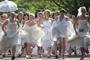 Mulheres vestidas de noiva participam de corrida (Ints Kalnins/Reuters)