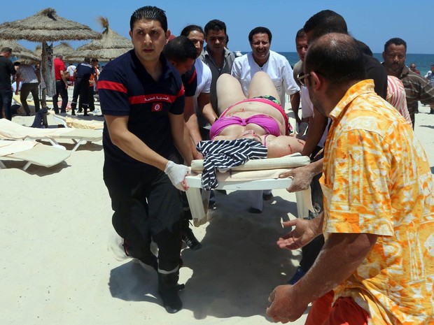 Mulher baleada é socorrida em uma maca em praia de Sousse, na Tunísia, após atentado terrorista (Foto: Fethi Belaid/AFP)