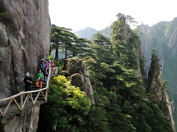 Turistas passam na cadeia montanhosa de Huangshan, na China (Foto: Mattes Ren/hemis.fr/AFP)
