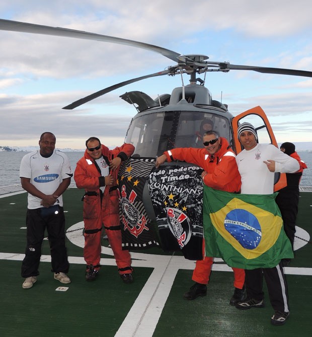 Vestidos com a camisa do Corinthians, militares brasileiros posam para foto na Antártica segurando bandeira do Brasil e do time paulista durante comemoração após a vitória no Mundial de Clubes (Foto: Divulgação/Marinha do Brasil)