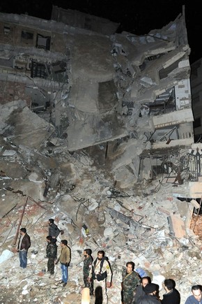 Foto divulgada pela agência síria Sana mostra forças do governo ao lado de prédio atingido por bombardeio israelense que tinha como algo um dirigente do Hezbollah, Samir Kantar. Ele morreu na ação (Foto: Sana/AFP) Foto divulgada pela agência síria Sana mostra forças do governo ao lado de prédio atingido por bombardeio israelense que tinha como algo um dirigente do Hezbollah, Samir Kantar. Ele morreu na ação (Foto: Sana/AFP)