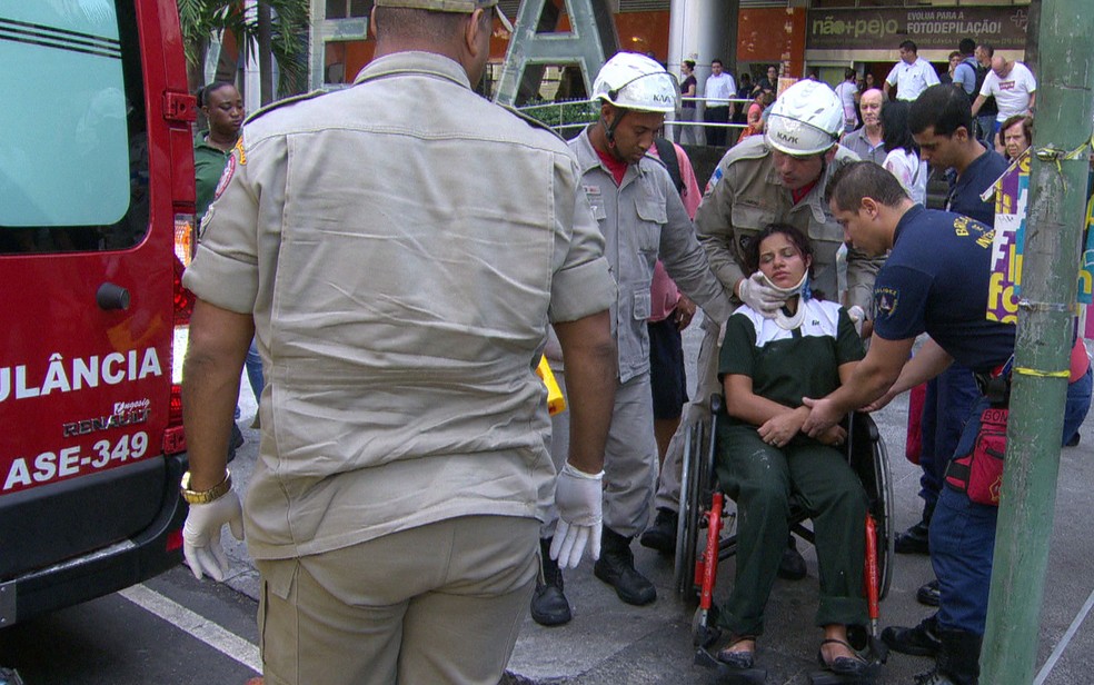 Funcionária ferida foi socorrida em cadeira de rodas (Foto: Reprodução/TV Globo)