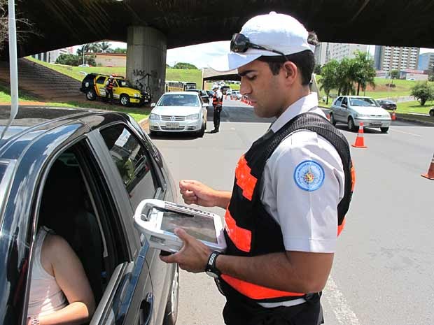 Policial Militar do DF utiliza tablet para consultar dados sobre veículo no DF durante blitz realizada nesta quarta (9) (Foto: Lucas Nanini/G1)