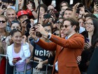 Com os cabelos maiores, Bradley Cooper tira fotos com fãs em première
