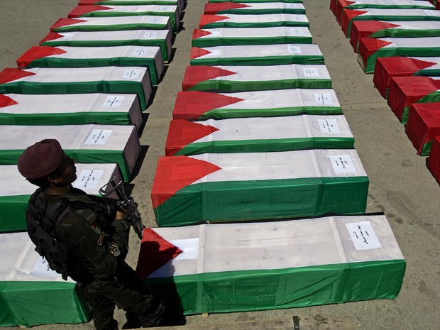 Guarda faz segurança dos caixões durante preparação para o funeral (Foto: AFP)