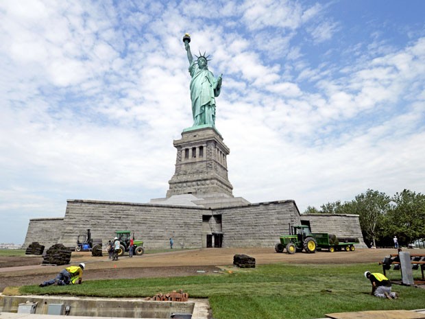 Nesta foto de 26 de junho de 2013, funcionários colocam terra em volta da Estátua da Liberdade; área passa por reparos (Foto: AP/National Park Service)