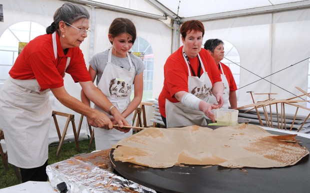 Competidoras tentam cozinhar maior crepe durante campeonato na França (Foto: Fred Tanneau/AFP)