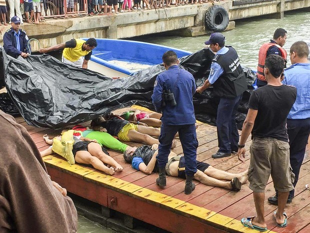 Membros da Força Naval e da polícia da Nicaraguá recebem os corpos dos mortos no naufrágio (Foto: STF/AFP)