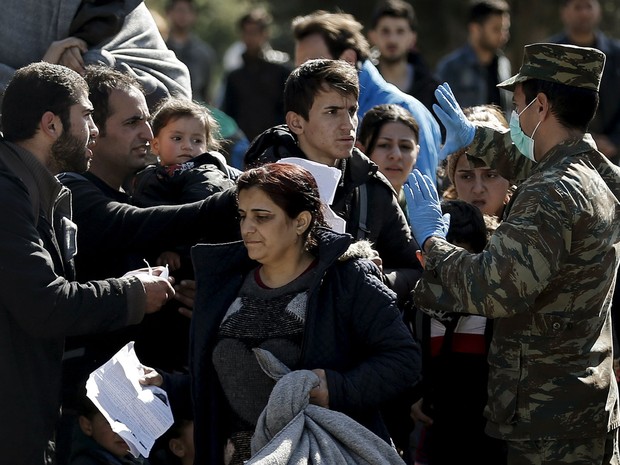 Policiais controlam documentos na fronteira da Grécia com a Macedônia nesta terça-feira (23) (Foto: Alkis Konstantinidis/ Reuters)