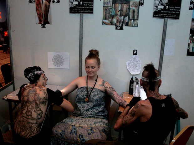 Turista estrangeira faz tatuagem durante Convenção Internacional de Tatuagem do Nepal, em Katmandu (Foto: Kyle Knight /AFP)
