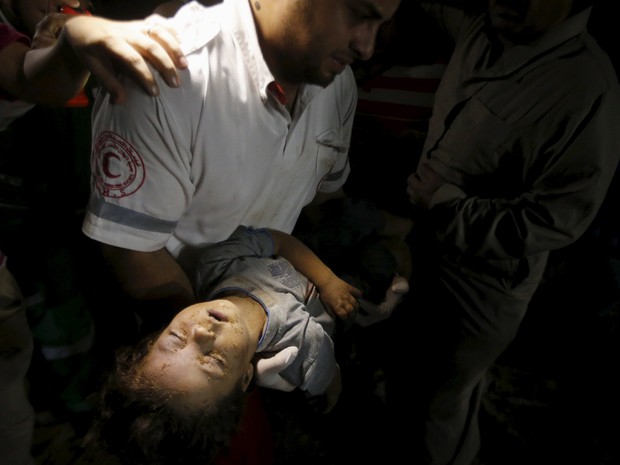Mdico segura corpo de uma menina palestina, que foi morta depois que sua casa foi derrubado por um ataque areo israelense em Gaza (Foto: Mohammed Salem/Reuters)