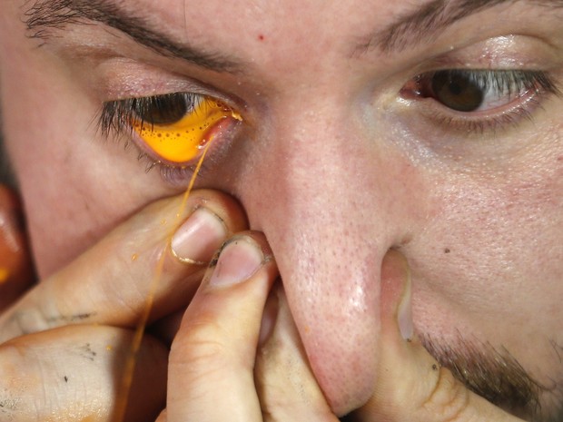 Leandro Granato espirra a tinta na tela usando os olhos (Foto: Enrique Marcarian/Reuters)