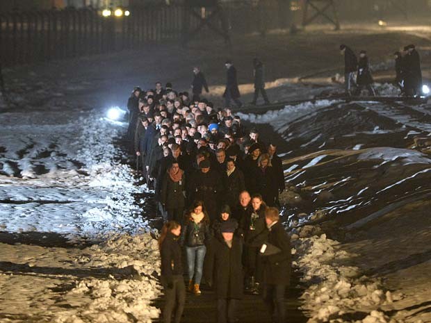 O presidente polonês Bronislaw Komorowski e convidados caminham no campo de Auschwitz para acender velas em homenagens às vítimas do Holocausto (Foto:  AFP PHOTO / JANEK SKARZYNSKI)