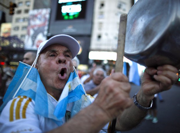 Manifestante bate panela durante protesto, nesta quinta-feira (8), em Buenos Aires.  (Foto: Natacha Pisarenko/AP)