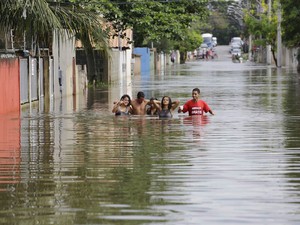 Moradores percorrem rua alagada da comunidade de Jacaraípe, no município de Serra, cerca de 25 km ao norte de Vitória (ES). (Foto: Nelson Antoine/Fotoarena/Estadão Conteúdo)