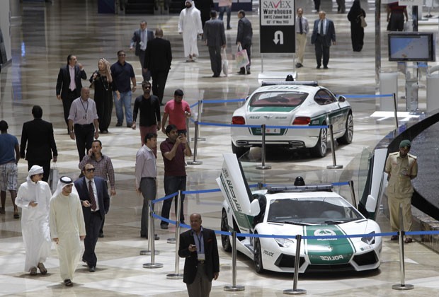 Visitantes observam Lamborghini Aventador, à frente, e Bentley Continental GT Coupe, dois dos supercarros da polícia de Dubai (Foto: Kamran Jebreili/AP)