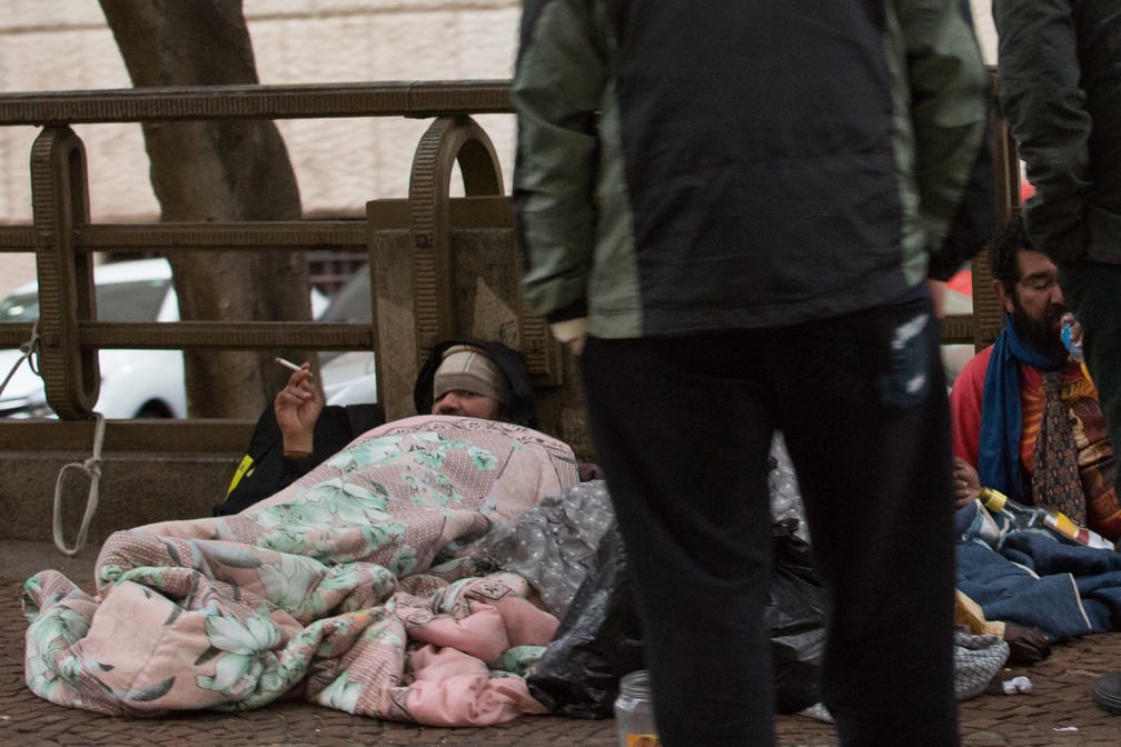Morador de rua se aquece com cobertor na Rua Líbero Badaró, no Centro (Foto: Celso Tavares/G1)