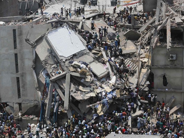 Multidão trabalha na retirada de vítimas de um desabamento em Savar, Bangladesh. O edifício de 8 andares que desabou abrigava um shopping center e fábricas de roupas nas imediações da capital Dhaka. (Foto: Andrew Biraj/Reuters)