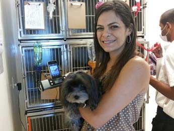 Paola mostra o aparelho que toca música clássica para os cães durante o banho e tosa (Foto: Isabella Formiga/G1 DF)