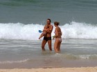 Ex-jogador Leonardo toma banho de mar com a mulher e o filho