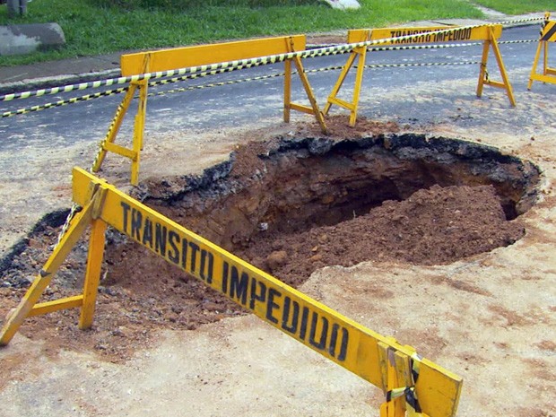 Buraco interdita rua em Poços de Caldas. (Foto: Reprodução EPTV)