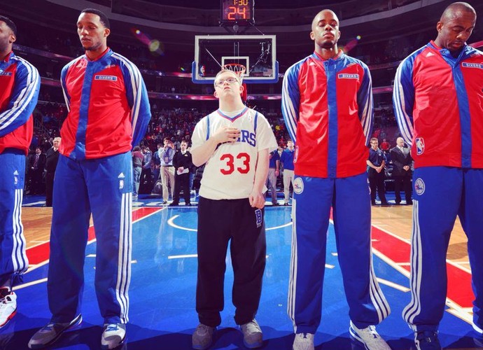 Kevin Grow se alinhou aos jogadores do Philadelphia 76ers durante a execução do hino nacional (Foto: Divulgação)