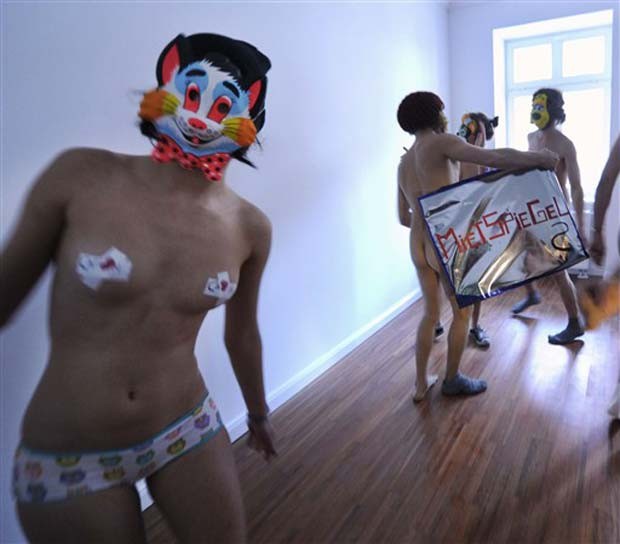 Em 2010, um grupo de ativistas protestou nu em Berlim, na Alemanha, contra o aumento do custo dos aluguéis na capital alemã. Após entrar em um imóvel colocado para locação, grupo tirou a roupa e começou a dançar usando máscaras e exibindo mensagens (Foto: Odd Andersen/AFP)