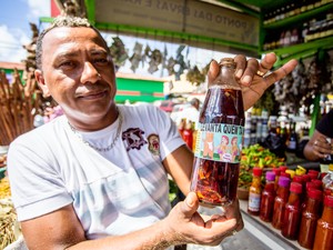 Comerciante exibe produto mais procurado na barraca, a garrafada &quot;Levanta quem tá morto&quot;. (Foto: Jonathan Lins/G1)