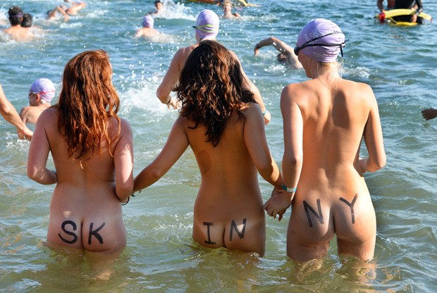 Banhistas sem roupas entram no mar para participar da prova (Foto: William West/AFP)