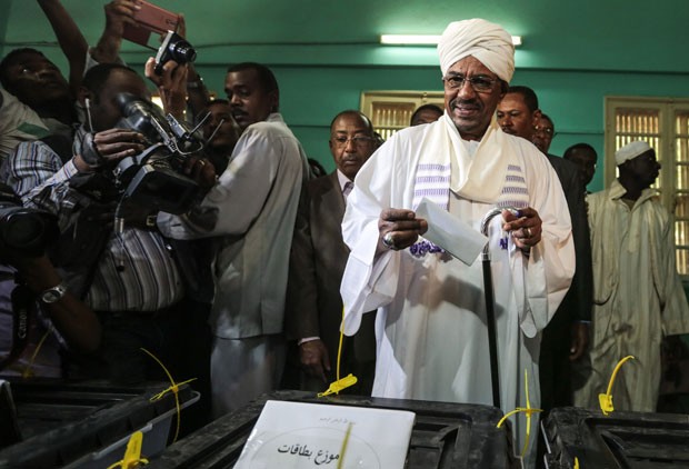 O presidente do Sudão, Omar al-Bashir, deposita seu voto durante as eleições presidenciais no país nesta segunda-feira (13) (Foto: Mosa'ab Elshamy/AP)