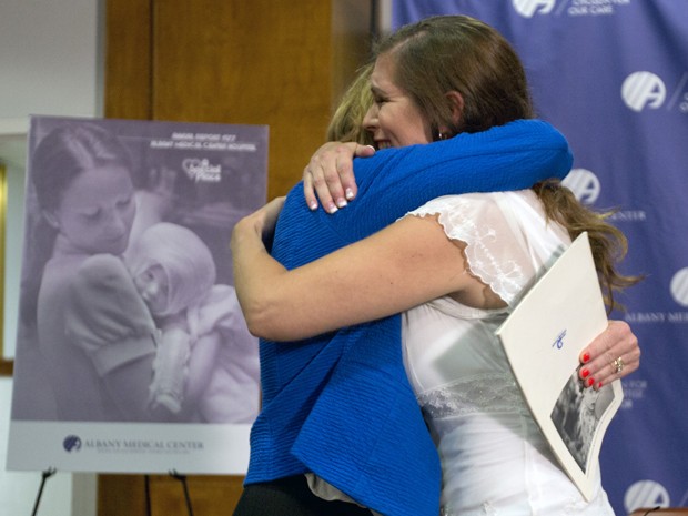 A enfermeira Susan Berger e Amanda Scarpinati se abraçam durante encontro no Albany Medical Center, na terça (29) (Foto: AP Photo/Mike Groll)