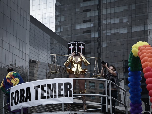 Já na Avenida Paulista, transexual cobre o rosto com referência à Bíblia (Foto: Caio Kenji/G1)