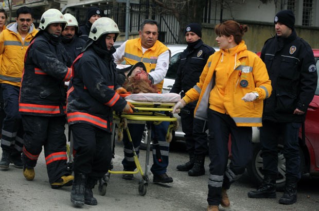 Mulher ferida é retirada de maca após explosão nesta sexta-feira (1º) em frente à embaixada dos EUA na Turquia, em Ancara (Foto: AP)