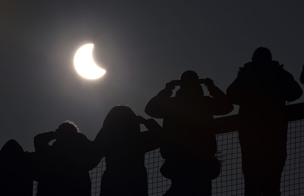 Pessoas assistem ao eclipse solar em Cornwall, na Inglaterra, nesta sexta-feira (20) (Foto: Ben Birchall/PA/AP)