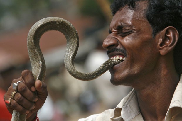  Sajal Biswas coloca cobra na boca. (Foto: Jayanta Dey/Reuters)
