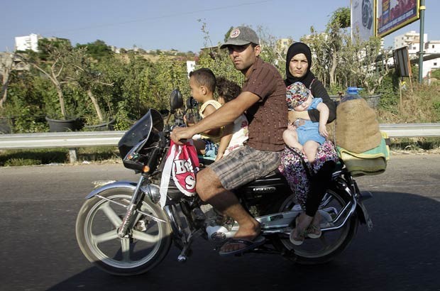 Família superlota motocicleta na rodovia Damur, ao sul de Beirute, capital do Líbano, neste sábado (14) (Foto: Joseph Eid/AFP)