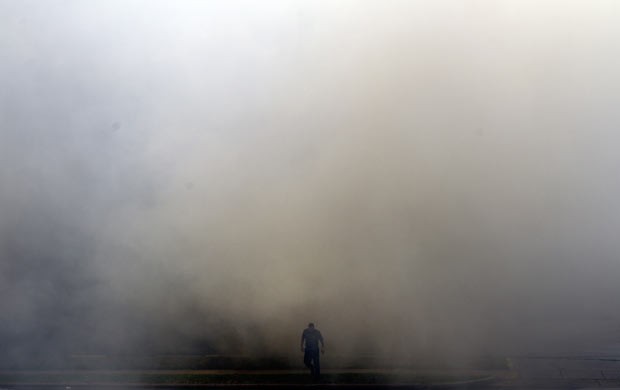 Bombeiro em meio à fumaça do incêndio nesta sexta-feira (31) em Houston, no Texas (Foto: AP Photo/Houston Chronicle, Cody Duff)