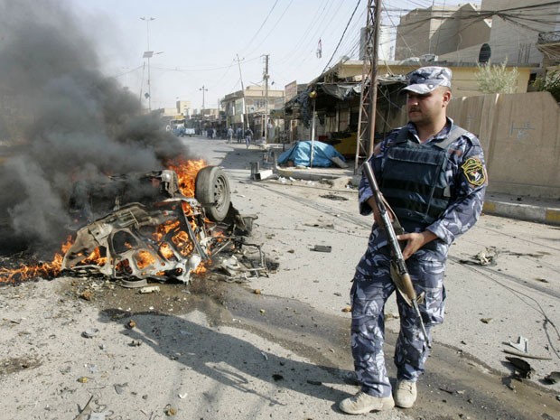 Policial preserva o local em que um carro explodiu, na cidade de Kirkuk (Foto: Ako Rasheed/Reuters)