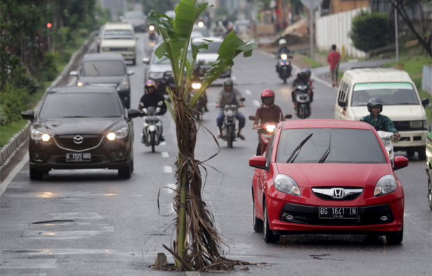 Indonésio protesta contra buraco de rua 'plantando bananeira' (Foto: REUTERS/Nova Wahyudi/Antara)