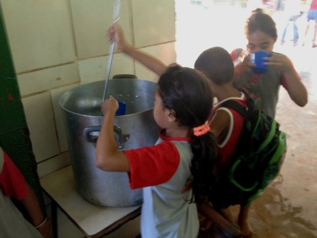 Crianças bebem água em panela transformada em bebedouro (Foto: Flaviane Azambuja)