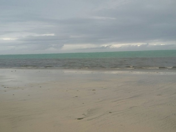 Areia da praia de Pajuçara também ficou escura e com mau cheiro (Foto: Derek Gustavo/G1)